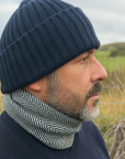 Man wearing a navy Merino Wool beanie hat with navy and white merino wool neck warmer