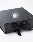 Black gift box with mairead hume logo on a white background