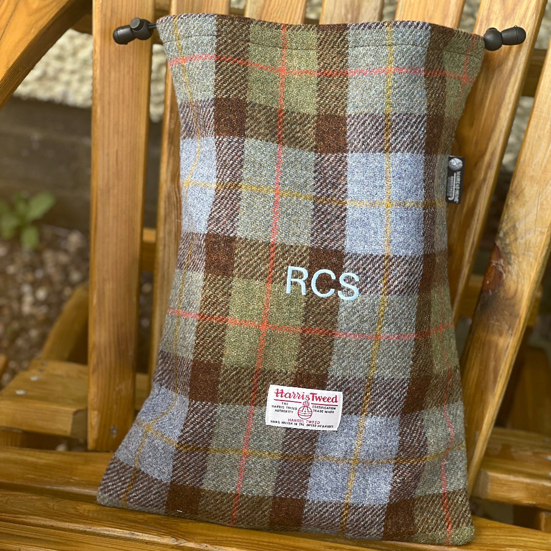 Harris Tweed fabric shoebagwith 'RCS' branding on a wooden chair