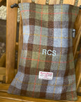 Harris Tweed fabric shoebagwith 'RCS' branding on a wooden chair
