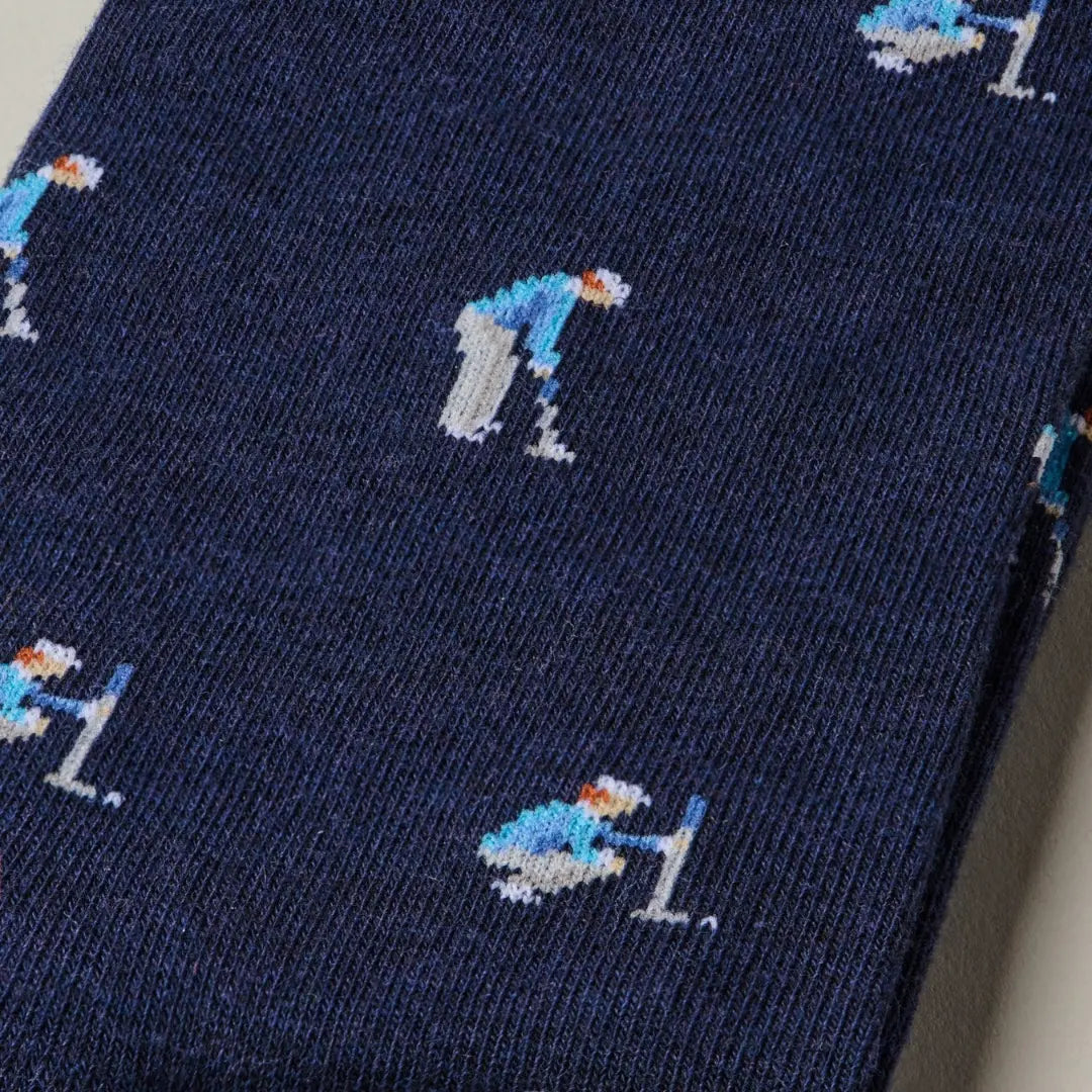 A close-up of a navy blue knit fabric, likely a scarf or sweater, featuring a repeating pattern of small pixelated hockey players in light blue, white, and orange.