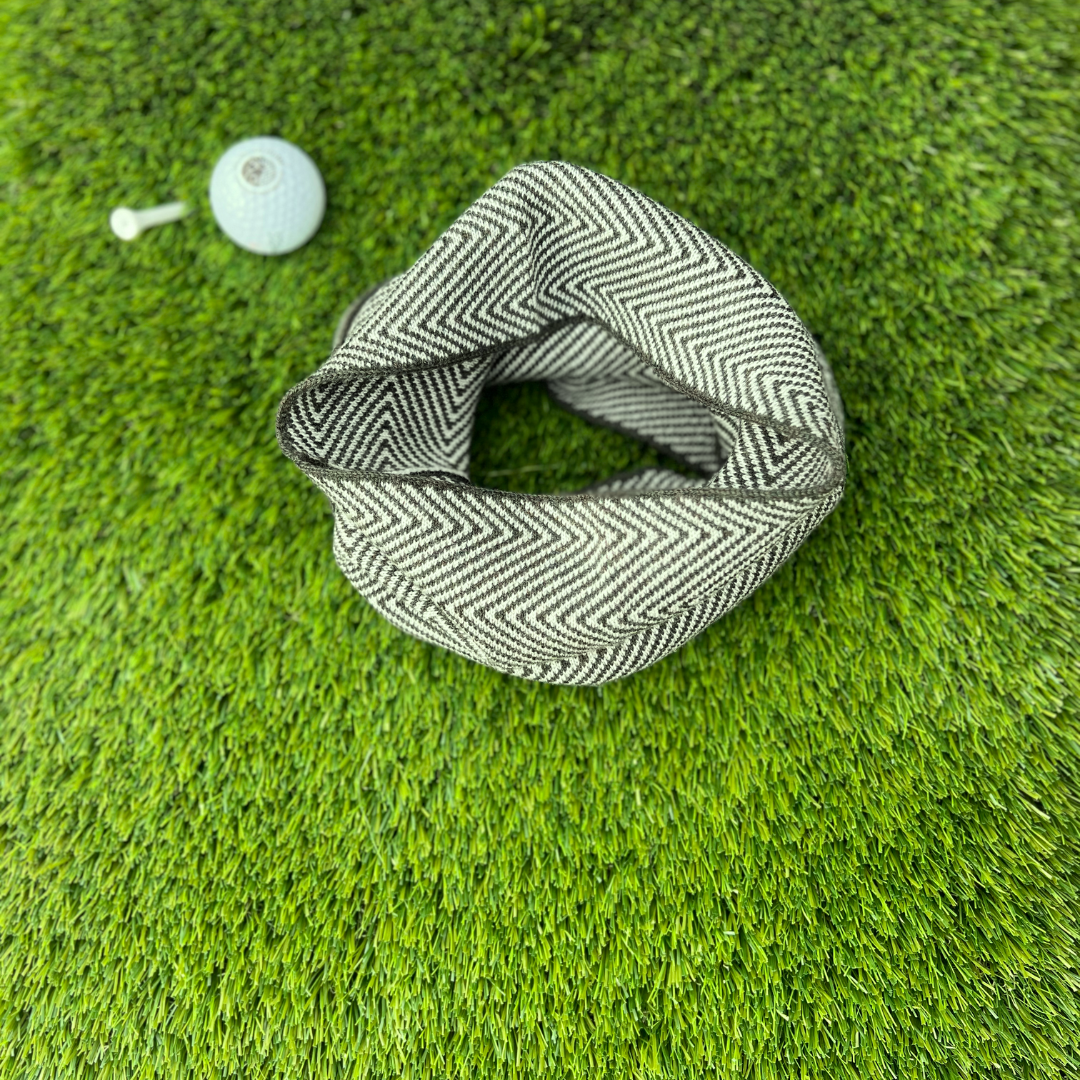 Patterned scarf golf ball marker on green grass